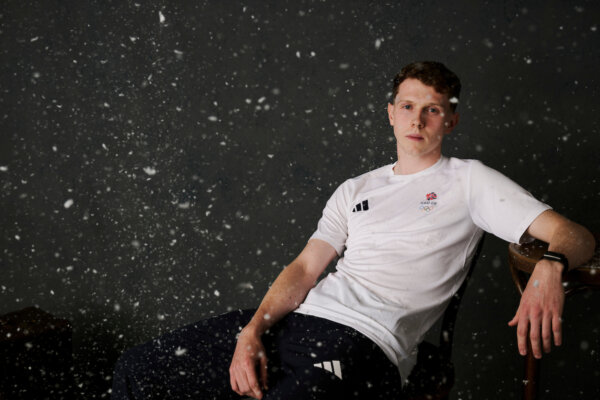 Team GB speed skater Niall Treacy in a studio portrait with snow falling around him.