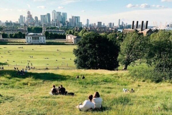 A couple enjoying London's skyline from Greenwich Park