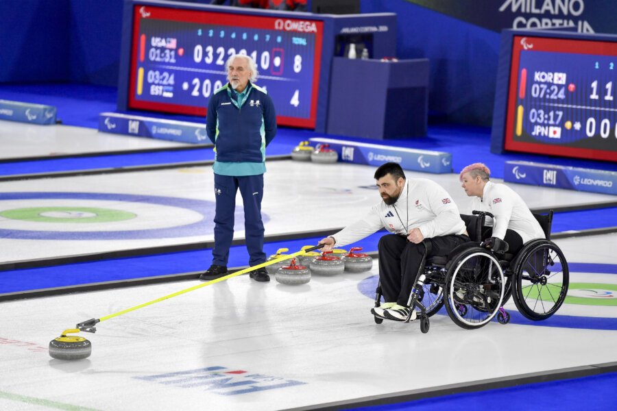 Two curlers in wheelchairs during a game.