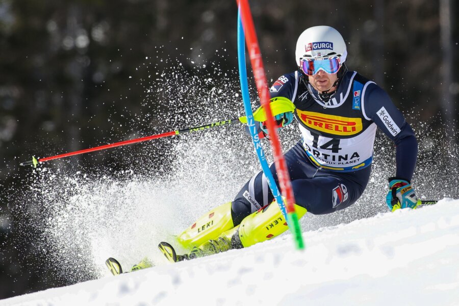 Skier descending a snowy slope during a winter sports competition.