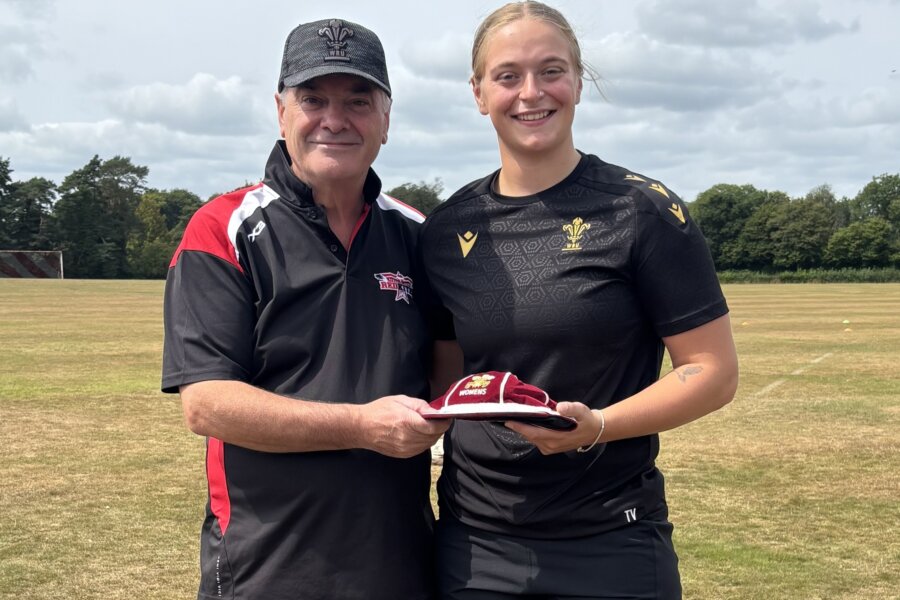Two rugby players in black jerseys posing for a photo.