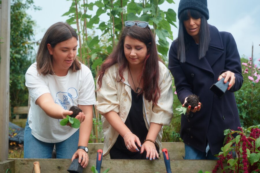 Claudia Winkleman gardening with two other people.