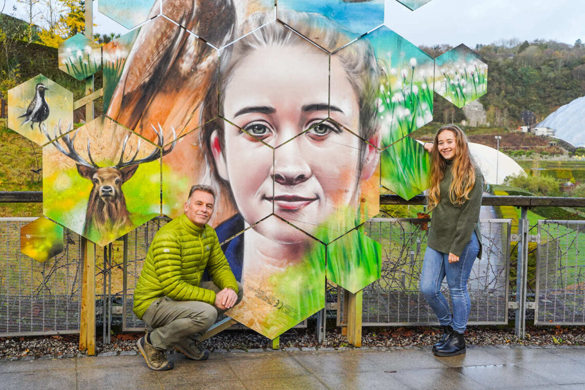 Two people (Chris Packham) and Milly Revill Hayward next to an artwork at The Eden Project.