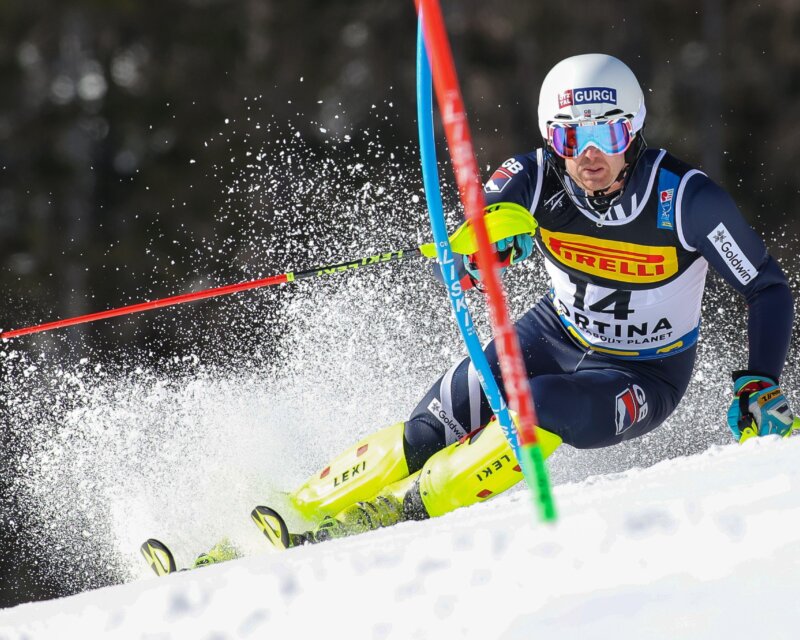 Skier descending a snowy slope during a winter sports competition.