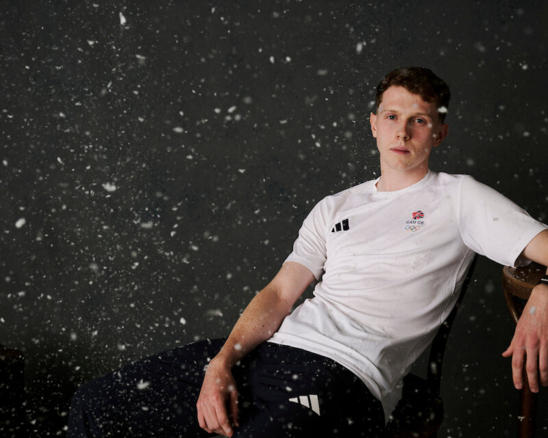 Team GB speed skater Niall Treacy in a studio portrait with snow falling around him.