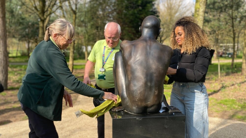 Three people (Amber, Malcom and Sue) cleaning up a memorial.