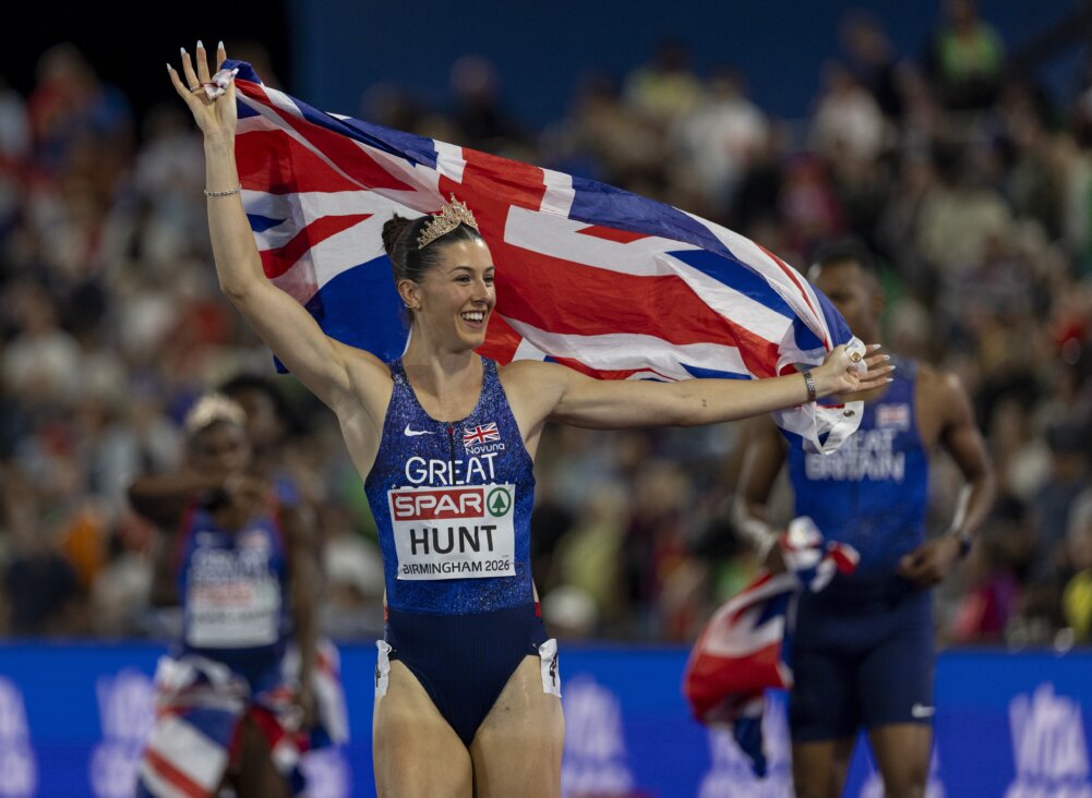 An athlete in lit that says 'Great Britain' celebrates holding a union jack.