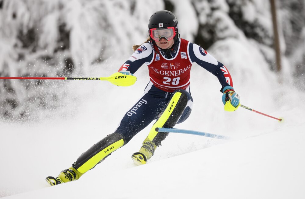 A woman (Charlie Guest) competing in the slalom ski category.