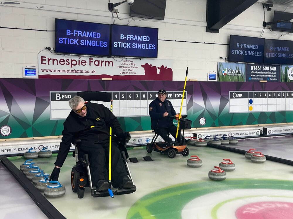 Two curlers in wheelchairs during a game.