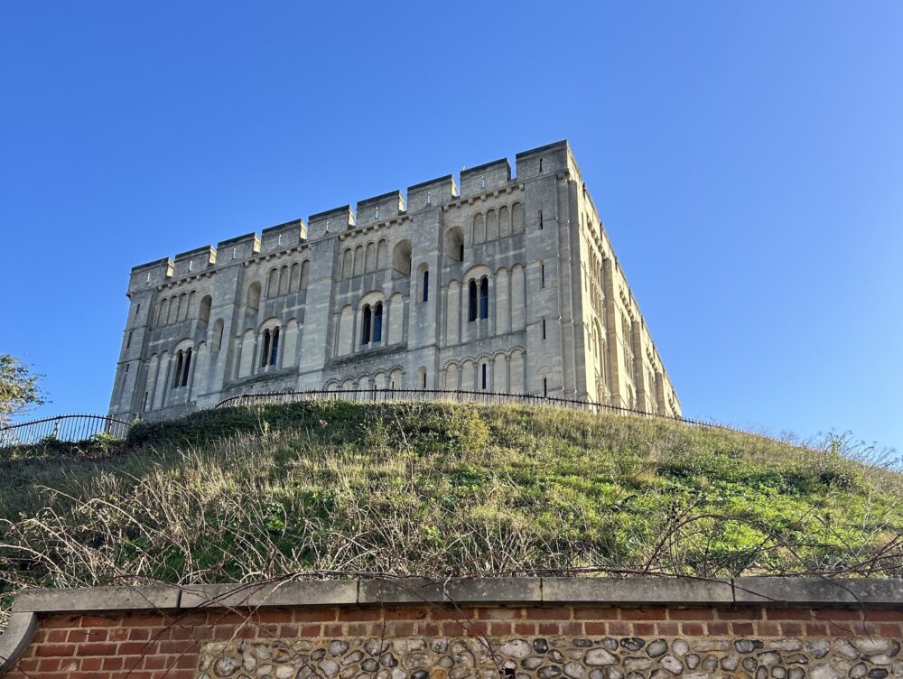 Historic stone castle on a hill under a clear blue sky.