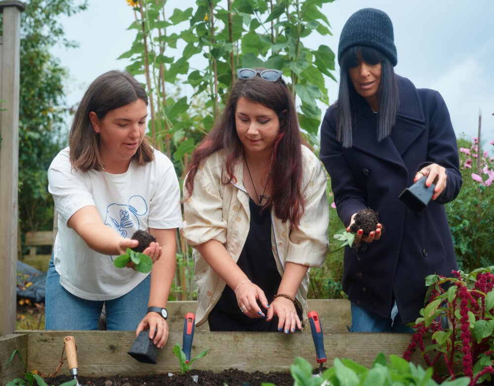 Claudia Winkleman gardening with two other people.