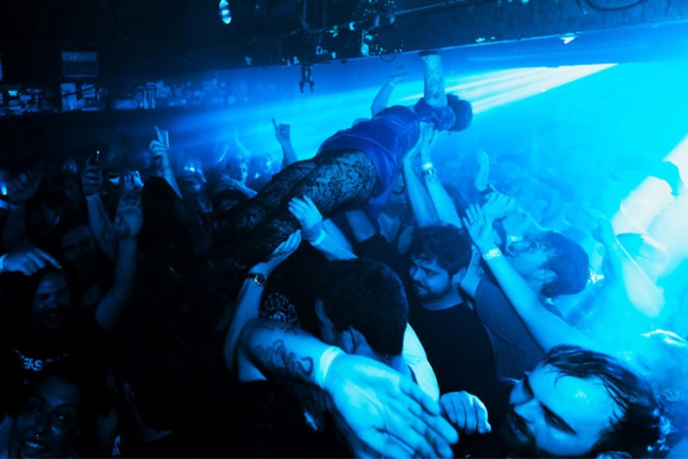 The inside of a music venue filled with people.