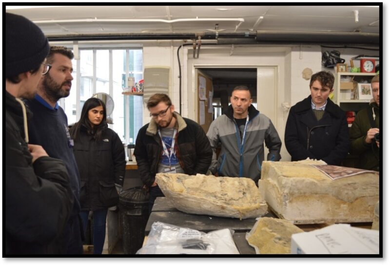 Tim and a group of HES bursary recipients at a skills session, pictured stood around a table with materials to be worked on
