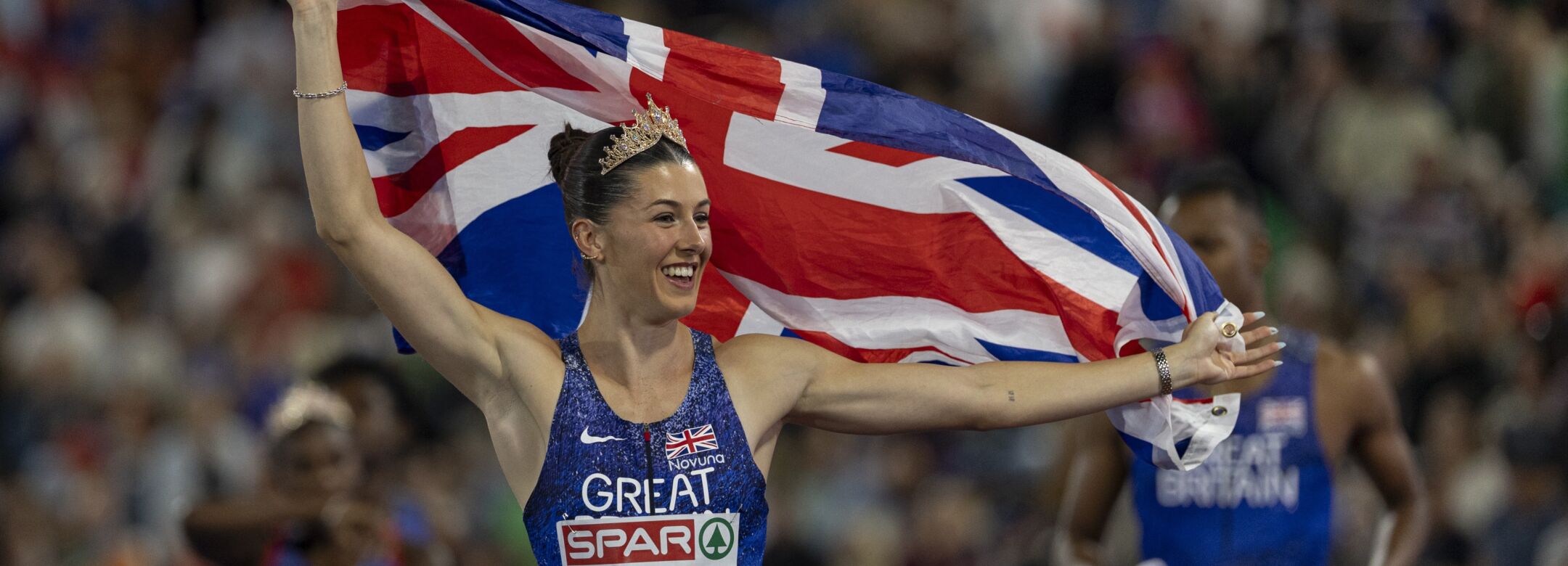 An athlete in lit that says 'Great Britain' celebrates holding a union jack.