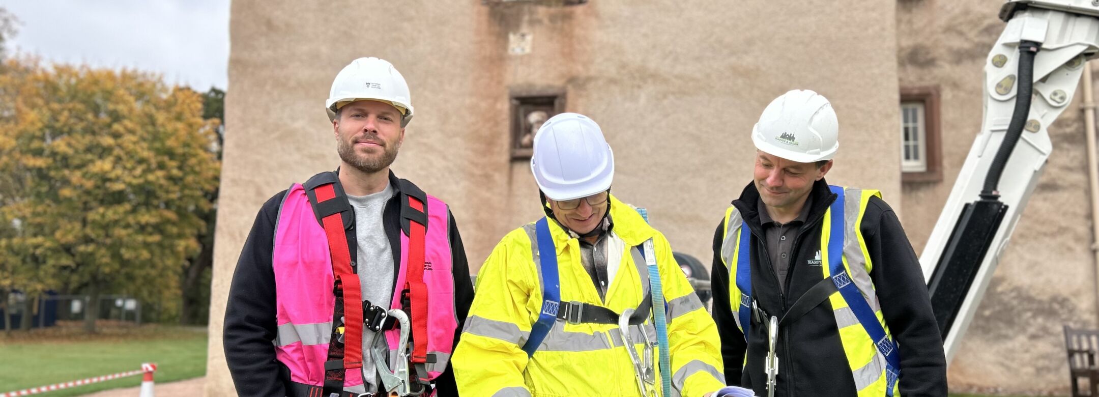 Three people in his vis jackets and hard hats.