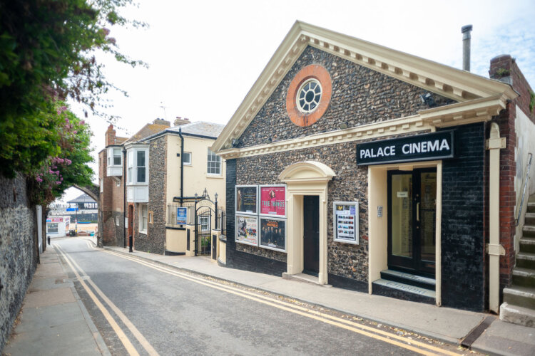 Street view of a small cinema in a historic building.