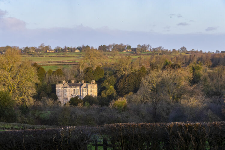 View of the 17th century Fountains Hall, nestled amongst trees at Fountains Abbey and Studley Royal Water Garden, North Yorkshire