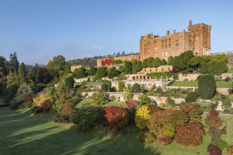 a large brick building at the top with split levels of garden, with a multitude of colours