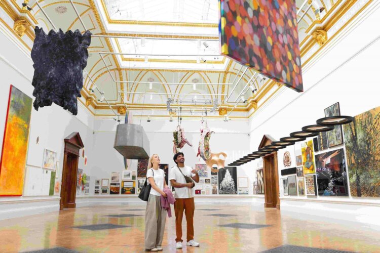 Gallery view of two people standing in the Summer Exhibition 2025