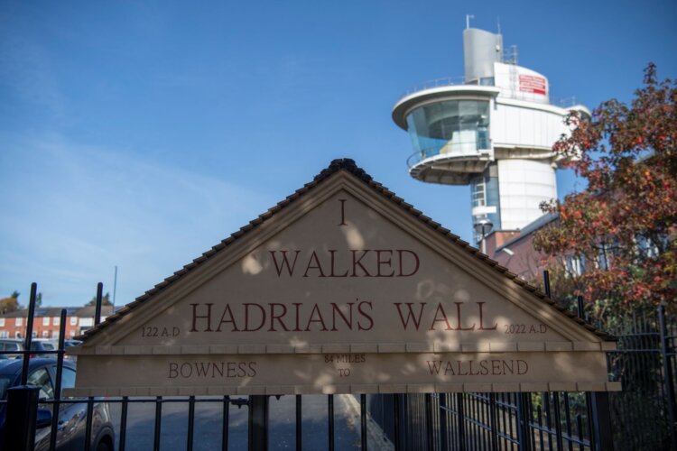 I walked Hadrian's Wall Stone monument with tall viewing tower in the background