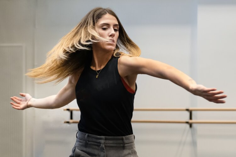 A woman moving dynamically in a bright studio space.