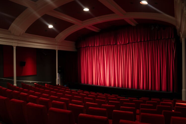 An image of Screen 1 at Filmhouse, a 187 seat cinema with beautiful red seats and a red velvet curtain.