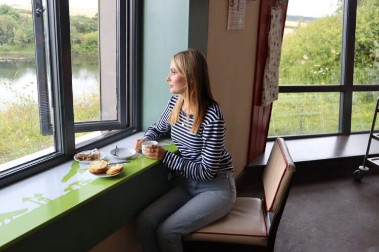 Someone enjoying a cuppa and the lovely view of the lake from the Lookout cafe