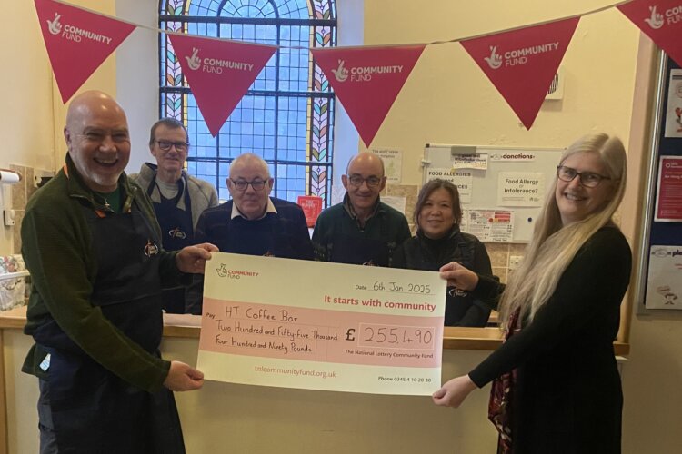 A group of people with a giant National Lottery funding cheque