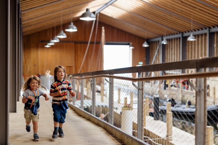 Two children running towards the photographer inside the Boat House and Wet Dock and Windermere Jetty Museum.