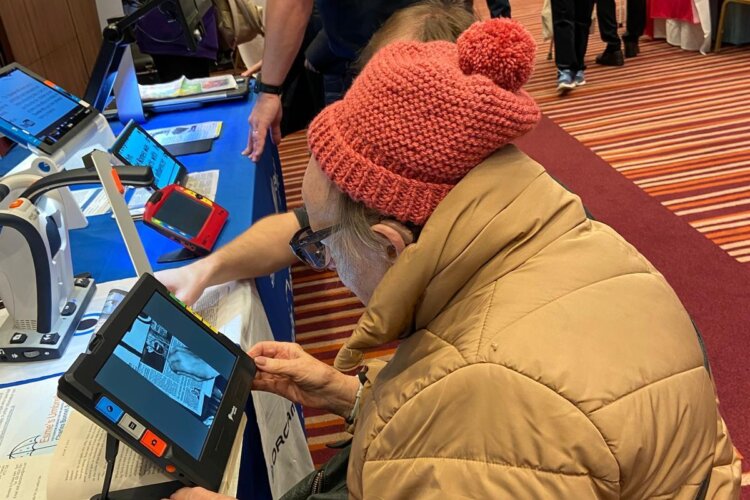 Photo of a lady trying out tan electronic magnifier