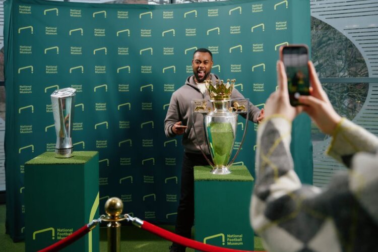 Visitor having their picture with the Premier League trophy at The National Football Museum