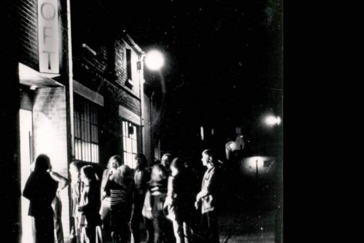 People queue up at a door to enter a cinema