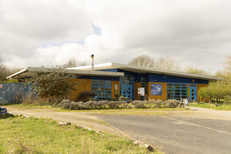 Alt=“Rye Meads visitor centre, a modern yellow and blue building”