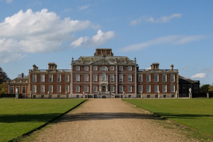 A large mansion stands at the end of a long pathway