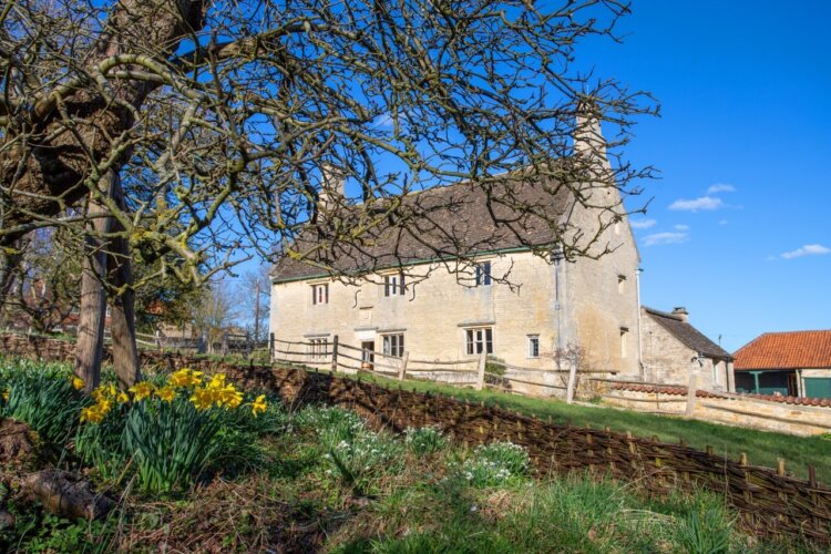 The exterior of the house in springtime sunshine at Woolsthorpe Manor, Lincolnshire