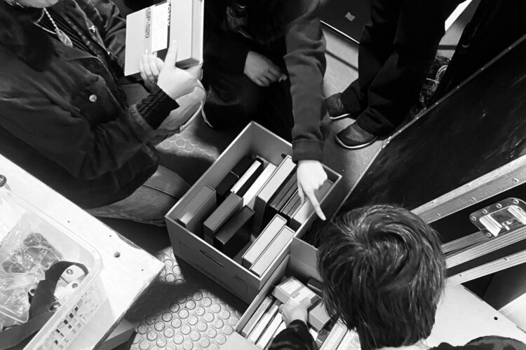 Black and white image of the BMAP group looking through boxes of video tapes.