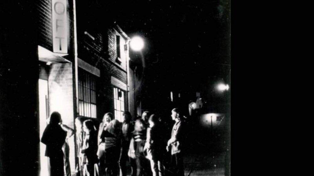 People queue up at a door to enter a cinema
